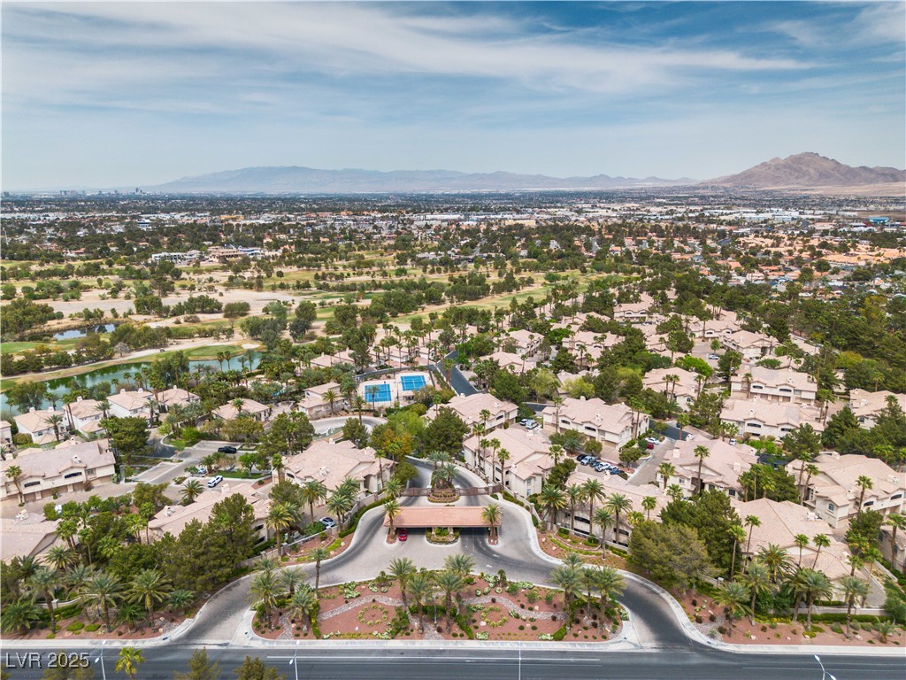 2050 West Warm Springs Road, Unit 1822 Henderson, NV 89014 - Photo 36 of 55 Aerial view featuring guard gate and waterscape entrance and clubhouse, as well as a residential view and a mountain view