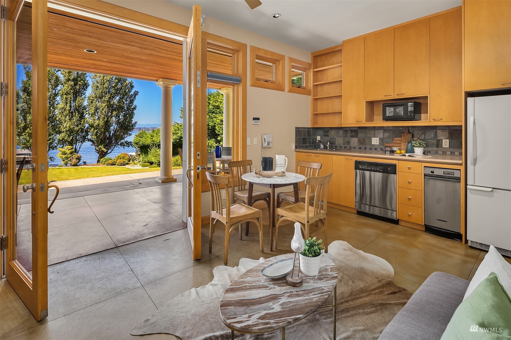 3235 Evergreen Point Road Medina, WA 98039 - Photo 35 of 39 a kitchen with stainless steel appliances kitchen island granite countertop a table and chairs in it