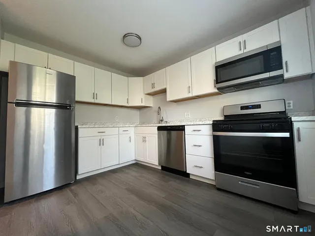 a kitchen with white cabinets and stainless steel appliances