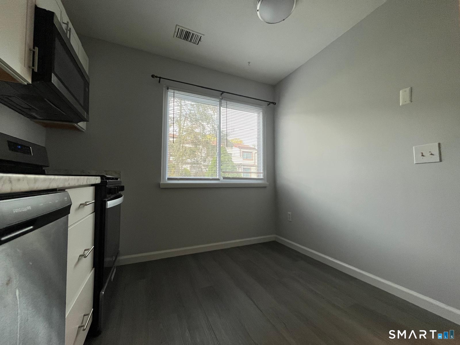 221 Cottonwood Road, Unit 221 Newington, CT 06111 - Photo 4 of 26 a room with wooden floor and a window