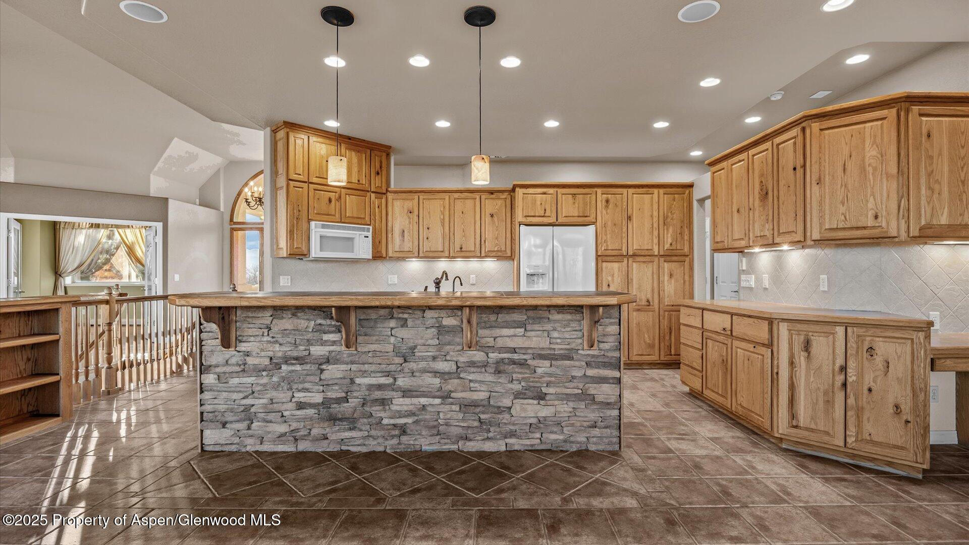 2426 H Road Grand Junction, CO 81505 - Photo 12 of 39 a bathroom with a granite countertop sink a large window and a refrigerator
