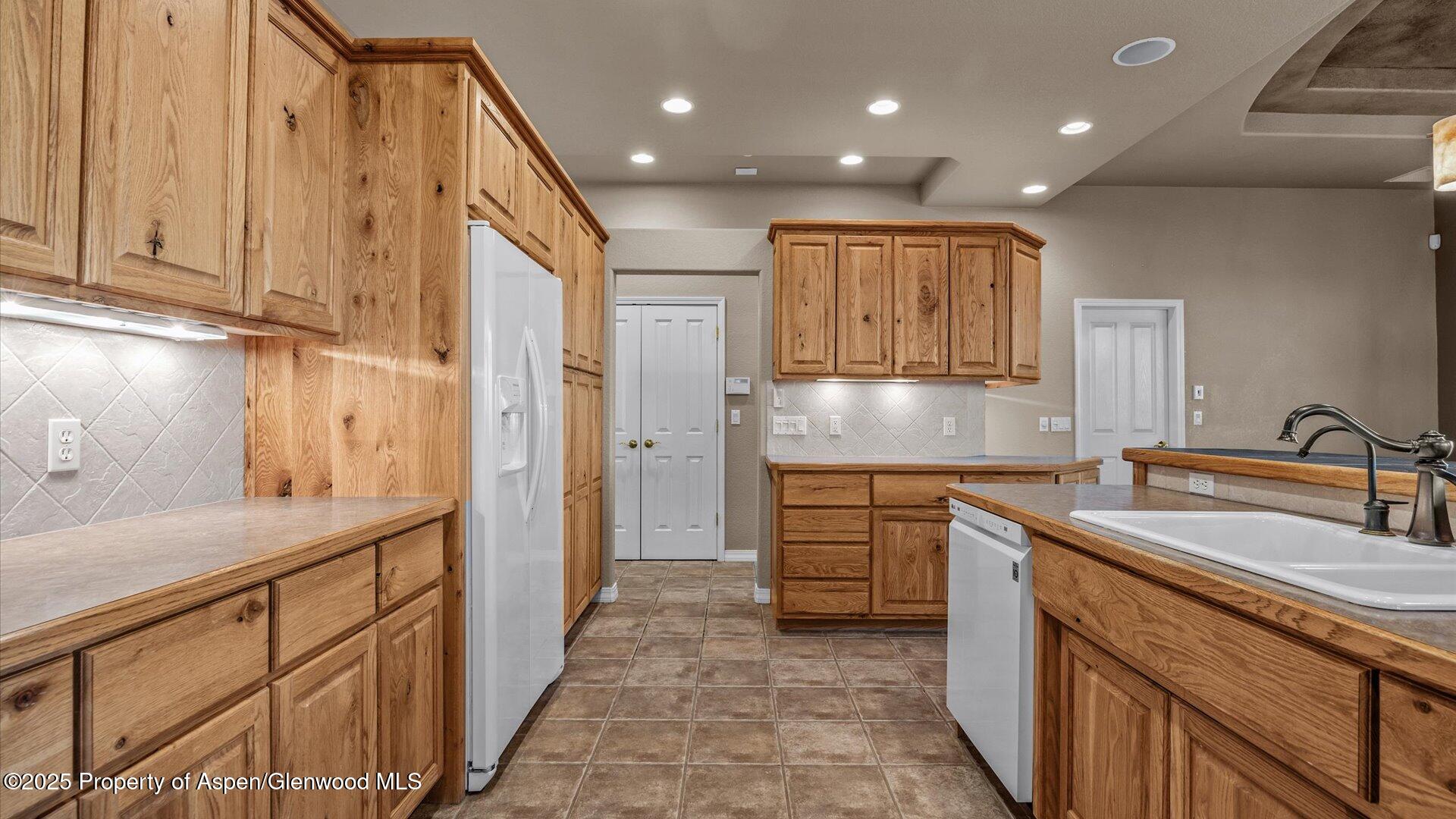 2426 H Road Grand Junction, CO 81505 - Photo 15 of 39 a kitchen with kitchen island granite countertop a sink and refrigerator