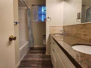 5728 Rockhill Road Fort Worth, TX 76112 - Photo 17 of 38 a bathroom with a granite countertop sink a toilet and shower