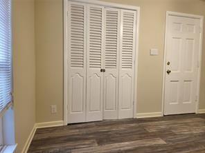 5728 Rockhill Road Fort Worth, TX 76112 - Photo 22 of 38 an empty room with wooden floor and windows