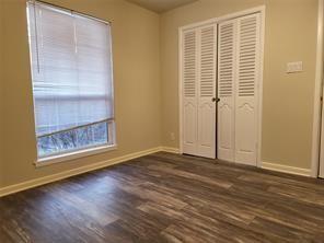 5728 Rockhill Road Fort Worth, TX 76112 - Photo 24 of 38 a view of an empty room with wooden floor and a window