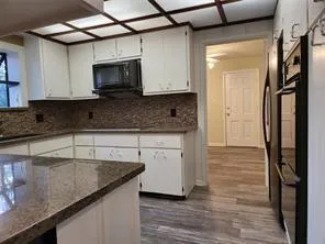 a kitchen with stainless steel appliances granite countertop a sink a stove and cabinets