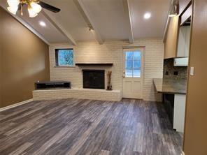 5728 Rockhill Road Fort Worth, TX 76112 - Photo 6 of 38 an empty room with wooden floor a fireplace and windows