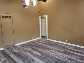 a view of an empty room with wooden floor