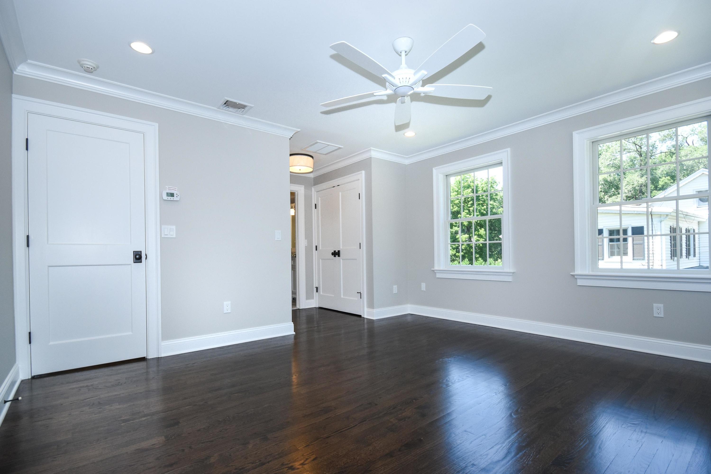 29 Brookside Road Darien, CT 06820 - Photo 14 of 26 an empty room with wooden floor chandelier fan and windows