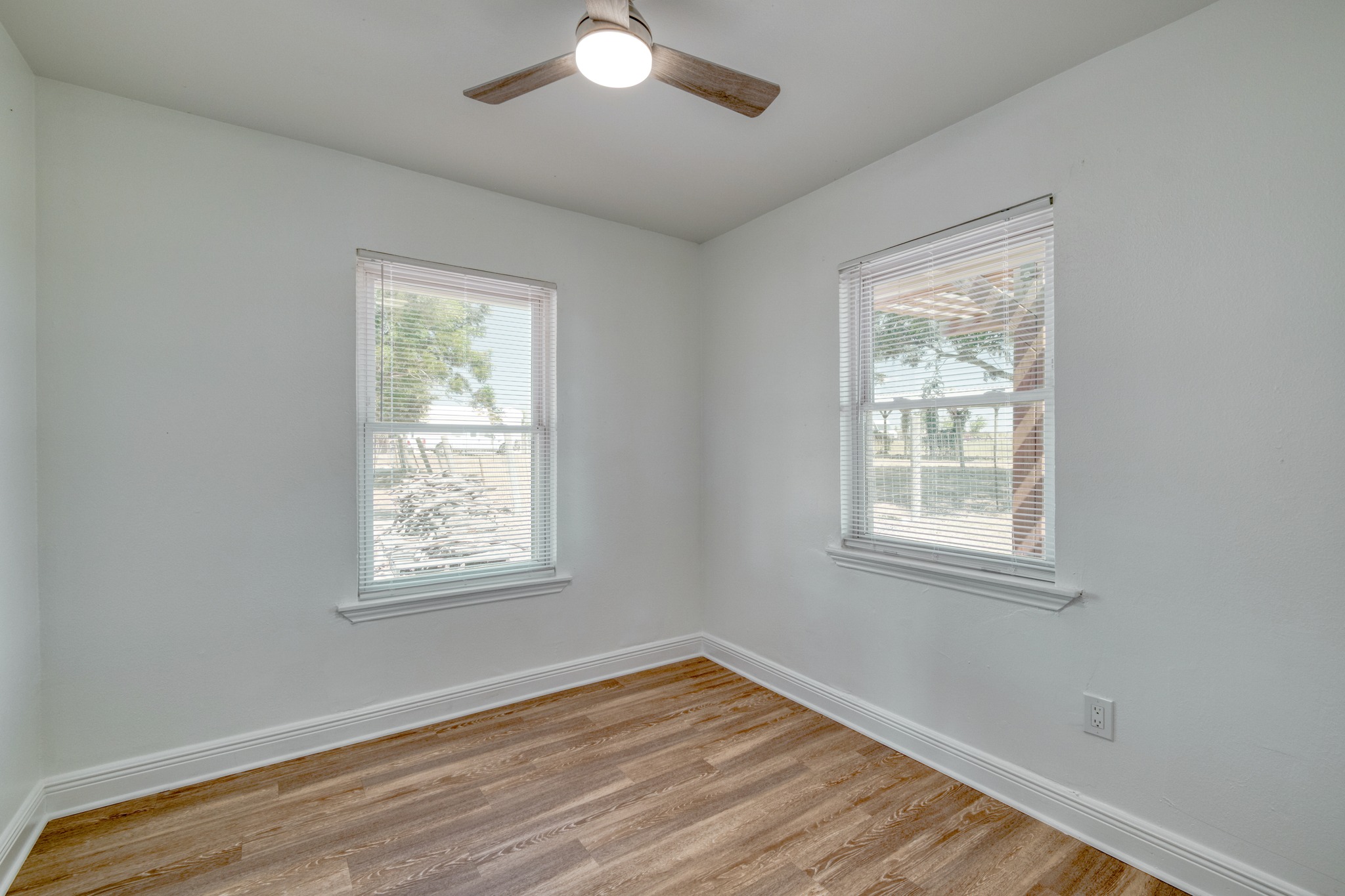 20960 Cameron Road Coupland, TX 78615 - Photo 12 of 21 Double windows frame outdoor views, while wood-look flooring adds warmth below.