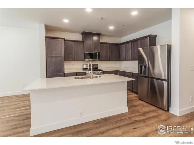 a kitchen with kitchen island a sink stainless steel appliances and cabinets