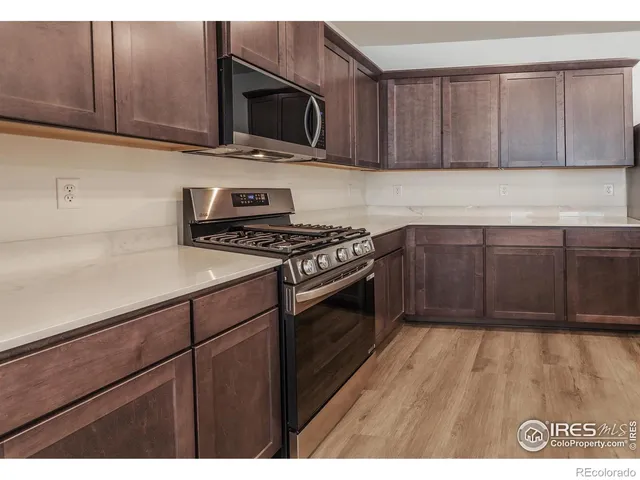 a kitchen with granite countertop wooden cabinets and a stove top oven