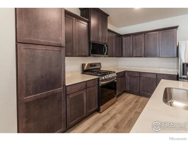 a kitchen with a refrigerator sink and cabinets