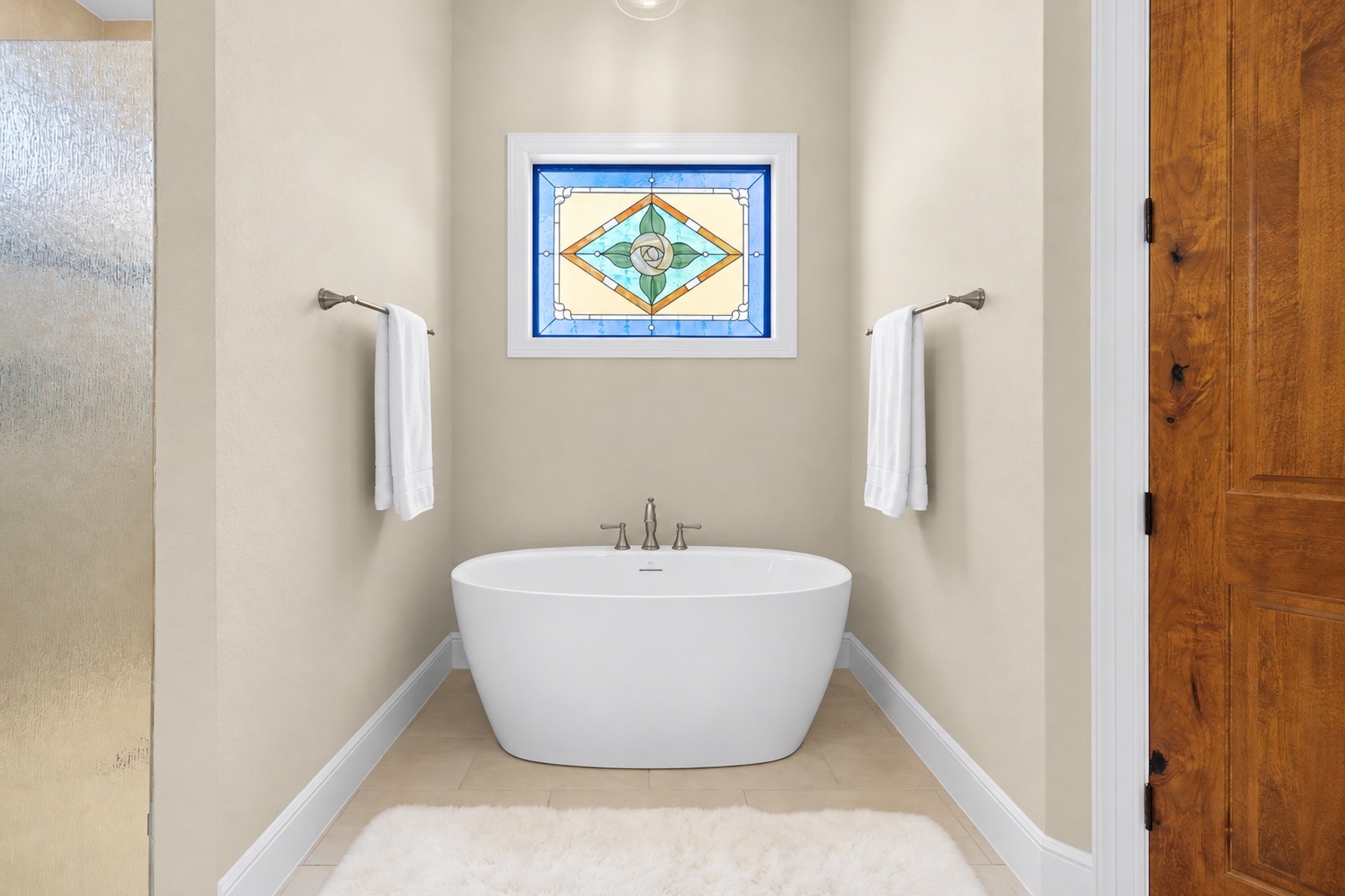 30163 High Spirit Ranch Road Hempstead, TX 77445 - Photo 24 of 46 The freestanding tub sits beneath a stained glass window, offering natural light and privacy.