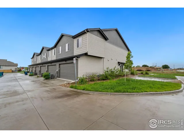 a view of a house with a yard and potted plants