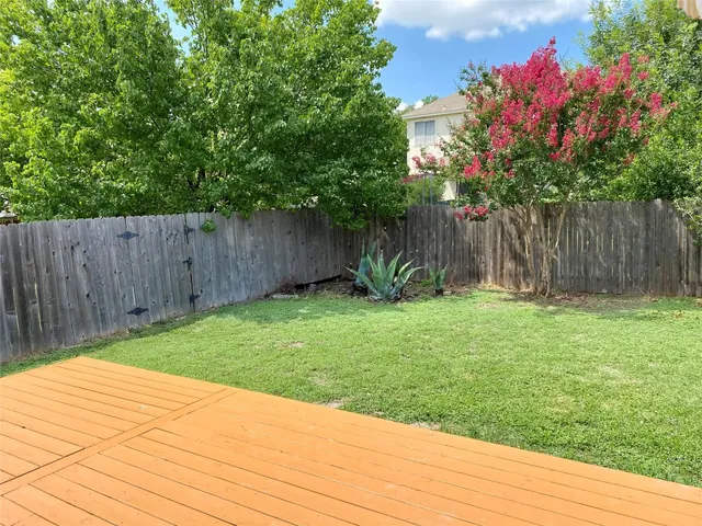 a backyard of a house with lots of green space and wooden fence