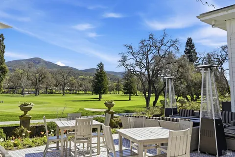 a view of a house with backyard and sitting area