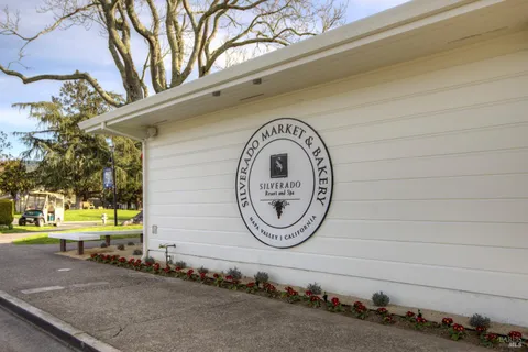a view of a chairs and table in patio with a yard