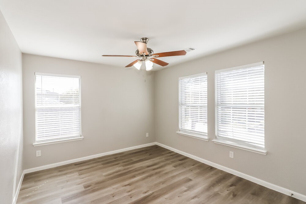 20622 Bishops Gate Lane Humble, TX 77338 - Photo 14 of 17 a view of an empty room with wooden floor and a window