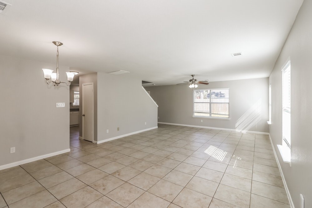 20622 Bishops Gate Lane Humble, TX 77338 - Photo 5 of 17 an empty room with chandelier fan and windows