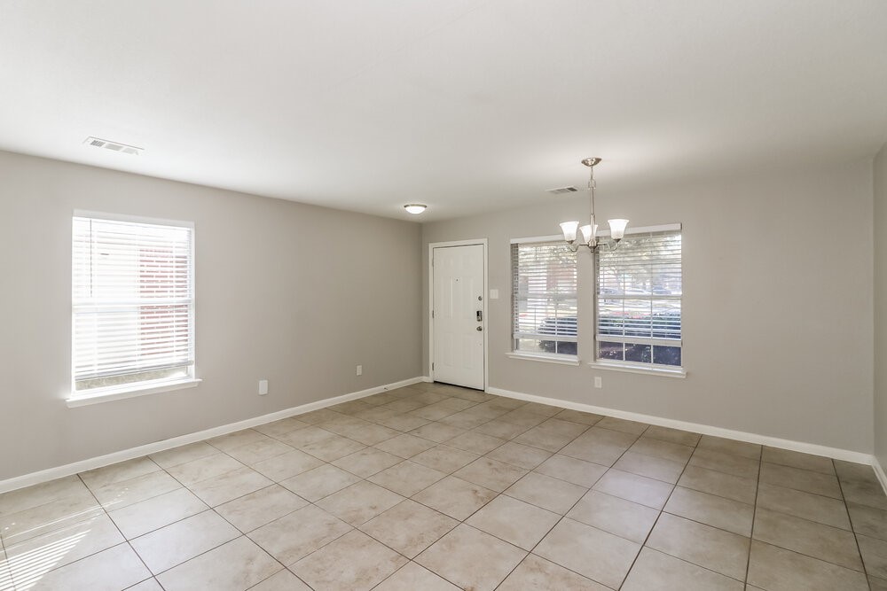20622 Bishops Gate Lane Humble, TX 77338 - Photo 7 of 17 an empty room with chandelier fan and windows