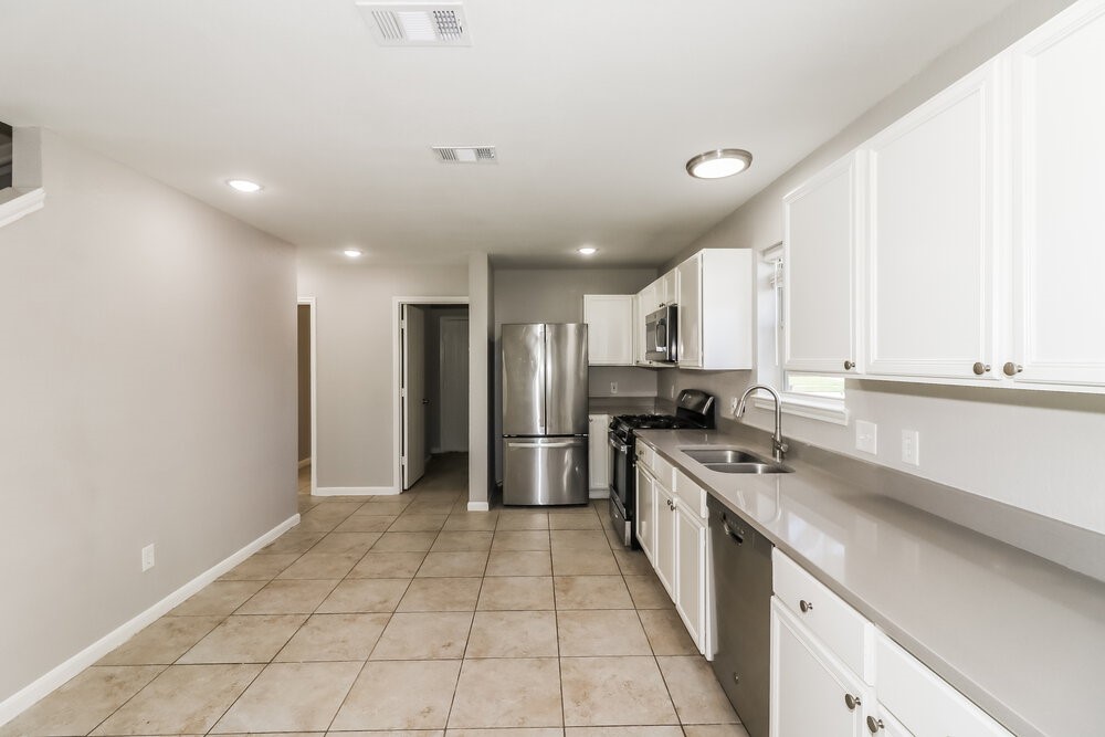 20622 Bishops Gate Lane Humble, TX 77338 - Photo 9 of 17 a kitchen with stainless steel appliances granite countertop a refrigerator a sink and a stove