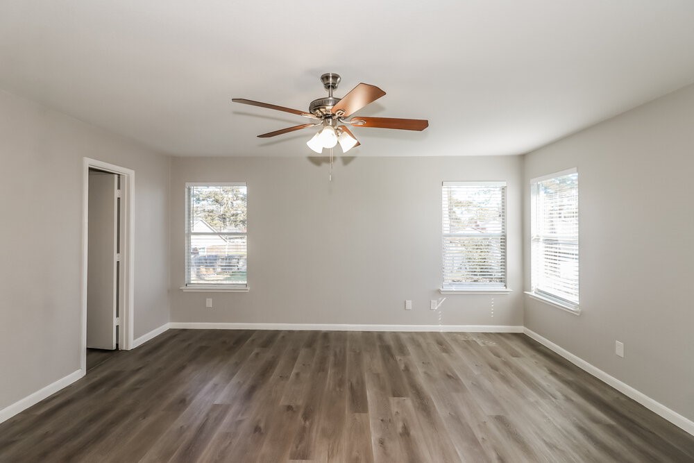 20622 Bishops Gate Lane Humble, TX 77338 - Photo 10 of 17 a view of an empty room with a window and wooden floor