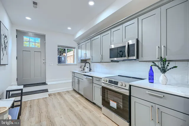 a kitchen with granite countertop a stove a sink and a microwave