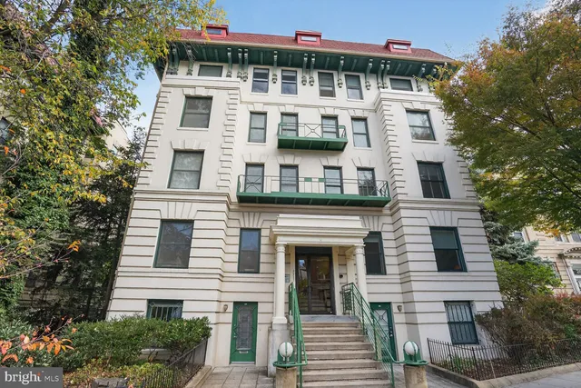 a front view of a residential apartment building with a yard