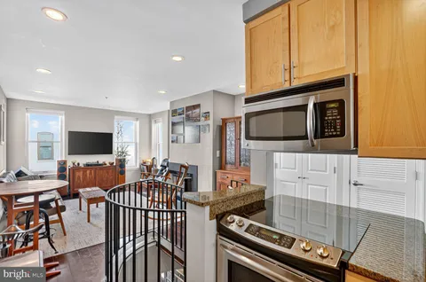 a living room with furniture a flat screen tv and kitchen view