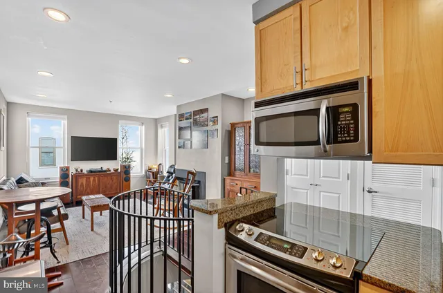 a living room with furniture a flat screen tv and kitchen view