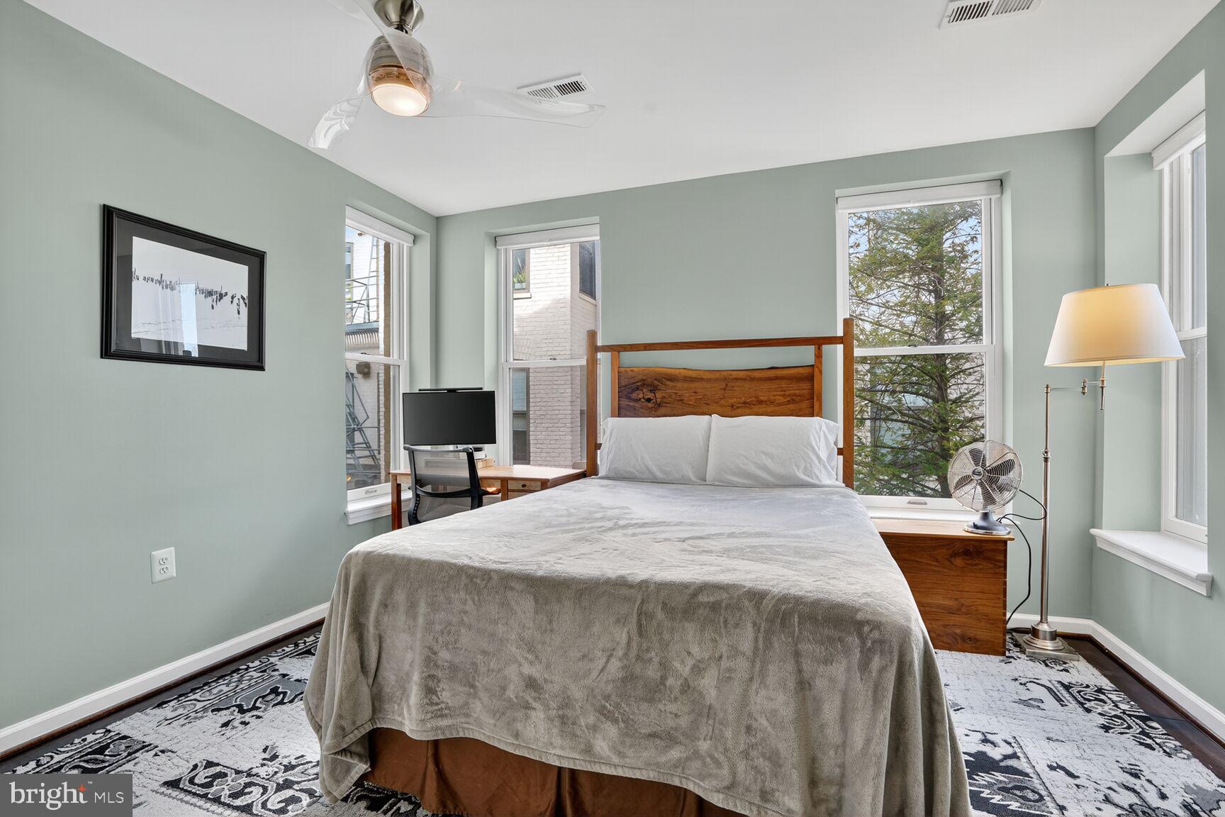 2627 Adams Mill Road Northwest, Unit 403 Washington, DC 20009 - Photo 18 of 38 a bedroom with a bed and wooden floor