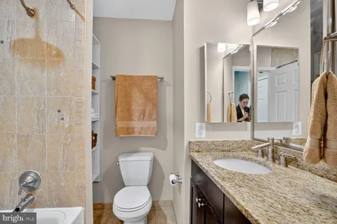 a front view of a building with lot of cars and trees