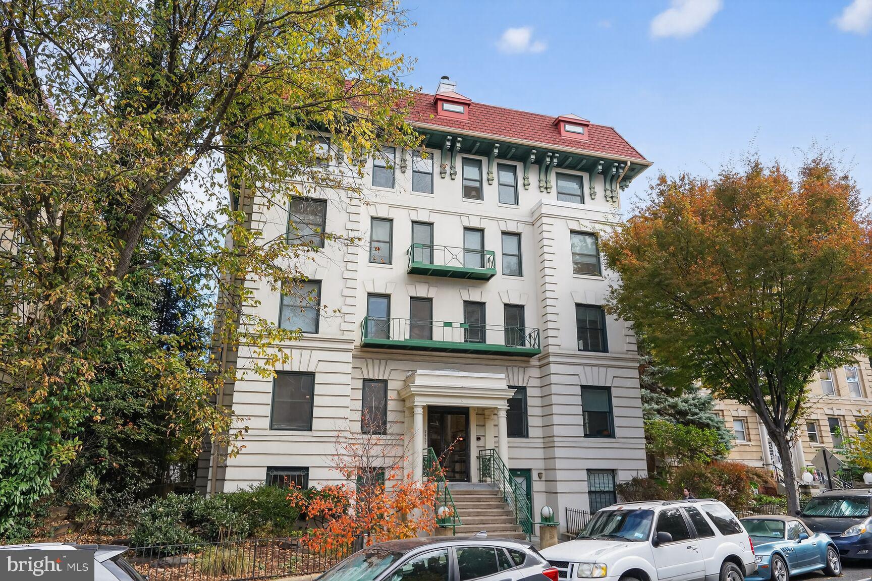 2627 Adams Mill Road Northwest, Unit 403 Washington, DC 20009 - Photo 27 of 38 a front view of a building with lot of cars and trees