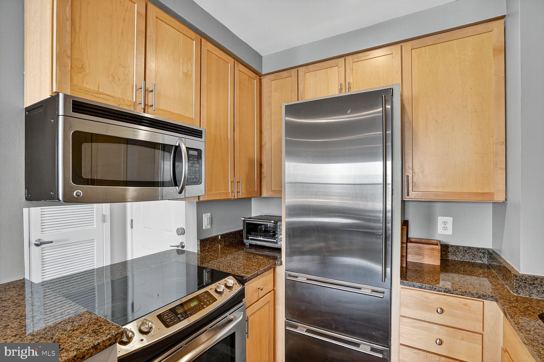 2627 Adams Mill Road Northwest, Unit 403 Washington, DC 20009 - Photo 9 of 38 a kitchen with a refrigerator stove and cabinets