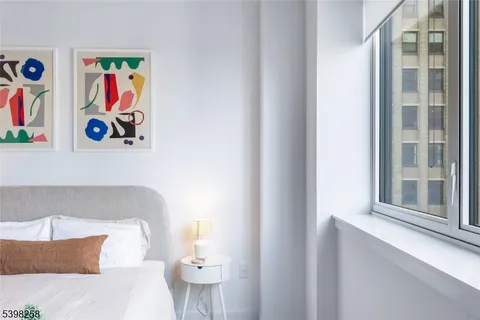 a bedroom with a bed and painting on the wall