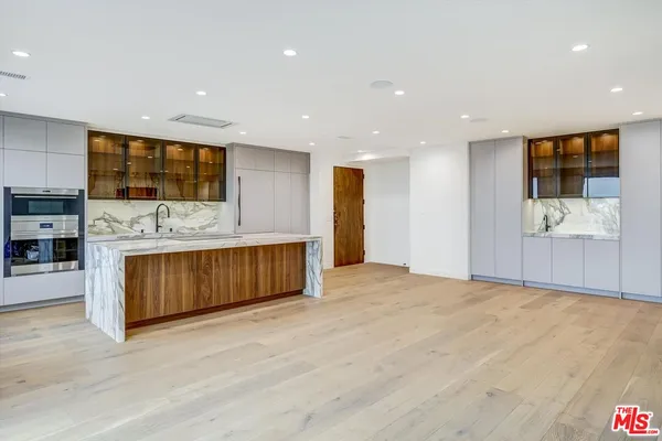 a view of kitchen with stainless steel appliances kitchen island granite countertop a stove a sink a refrigerator and a microwave