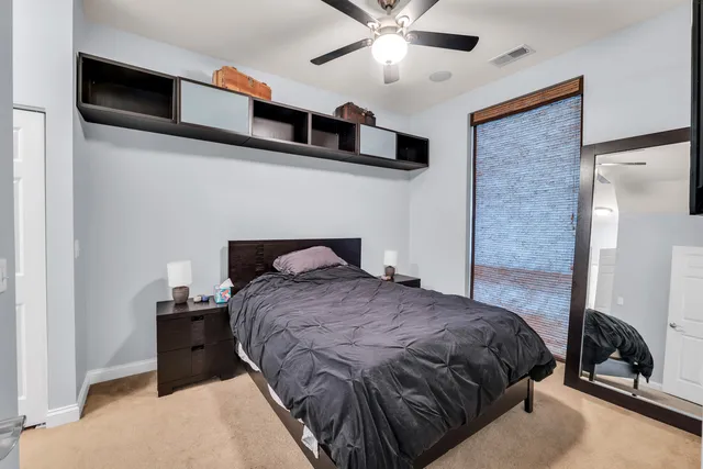 a bedroom with a bed and a ceiling fan