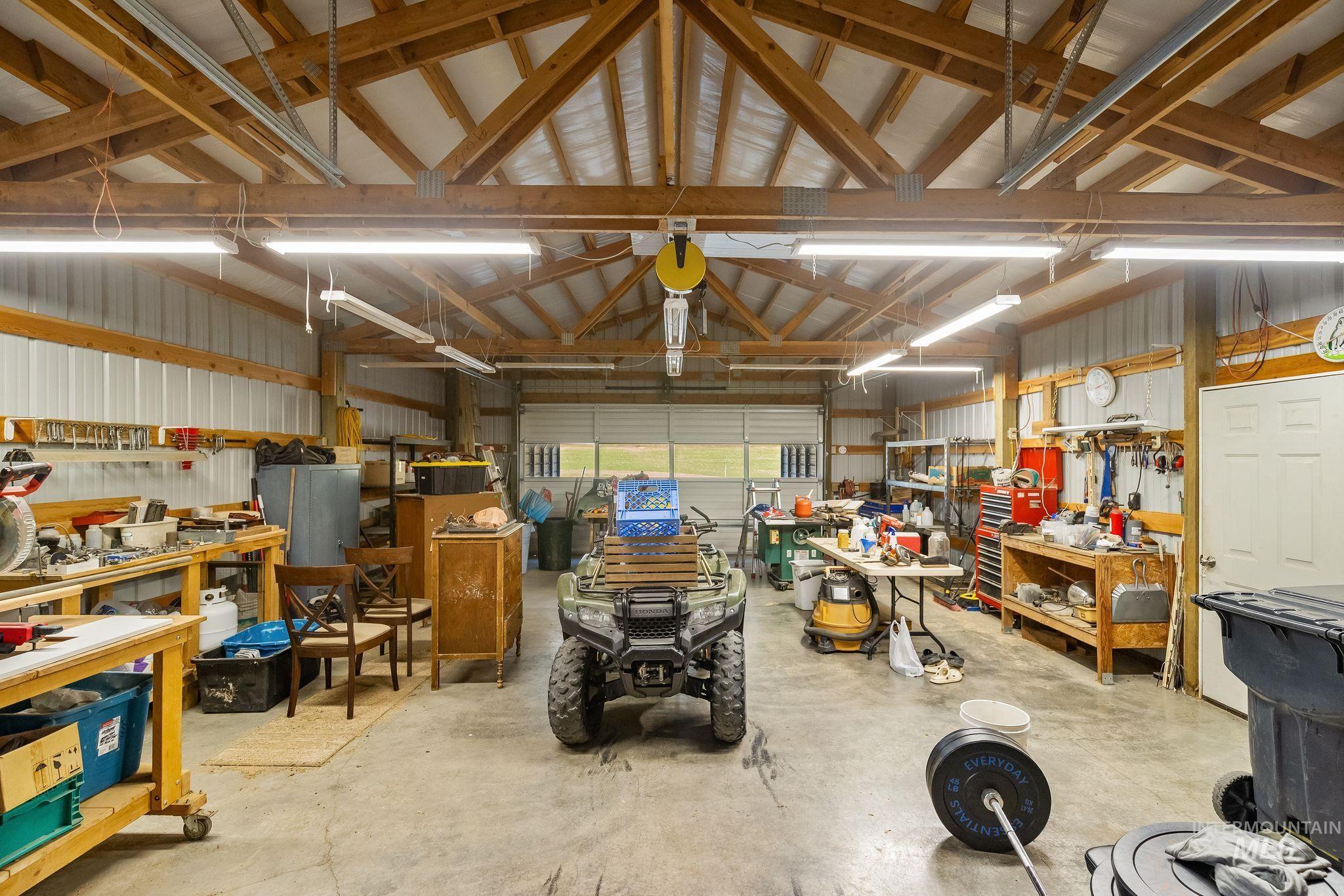 4935 Lenville Road Moscow, ID 83843 - Photo 41 of 49 Spacious workshop with exposed wood beam ceiling, concrete flooring, and multiple fluorescent light fixtures