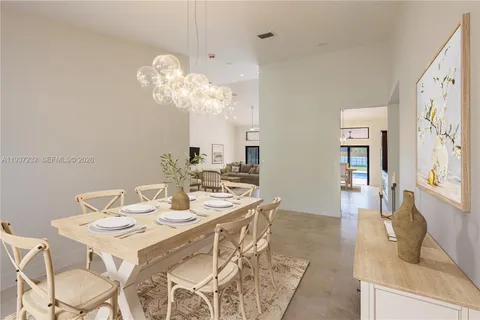 a dining room with wooden floor a chandelier a wooden table and chairs