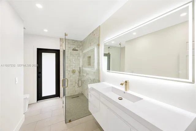a bathroom with a bathtub shower sink and mirror
