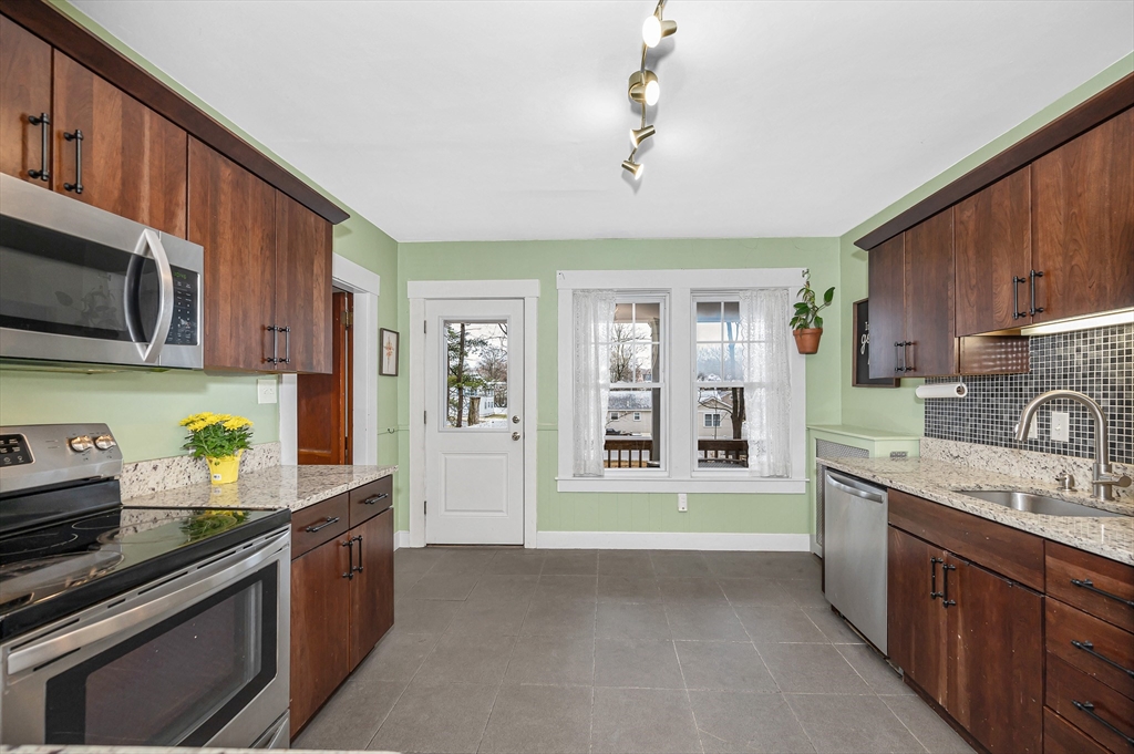567 Andover Street, Unit A Lowell, MA 01852 - Photo 14 of 35 a kitchen with stove cabinets and a sink