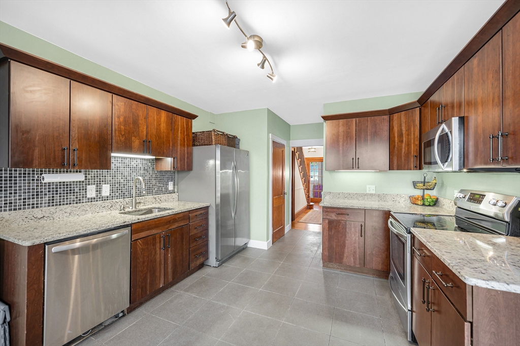 567 Andover Street, Unit A Lowell, MA 01852 - Photo 16 of 35 a kitchen with stainless steel appliances granite countertop a sink stove and refrigerator