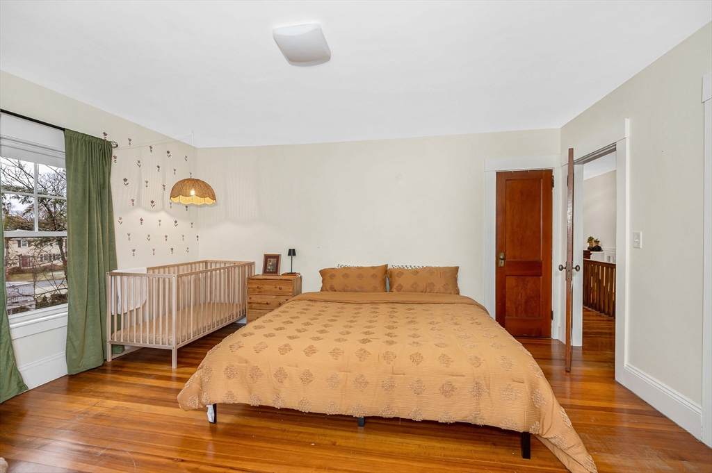 567 Andover Street, Unit A Lowell, MA 01852 - Photo 23 of 35 a bedroom with a bed and wooden floor