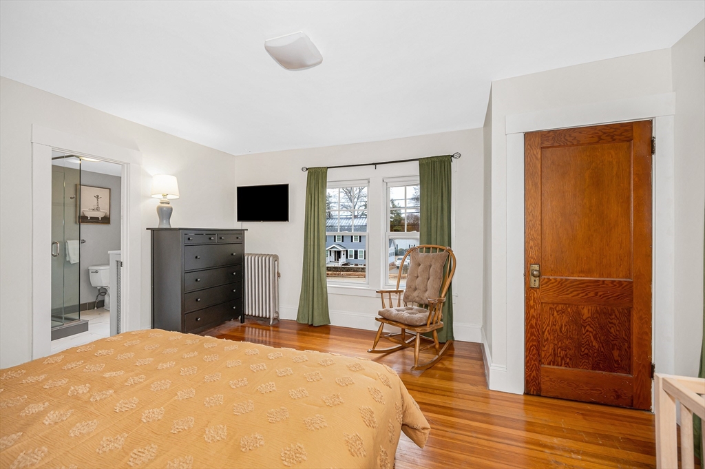 567 Andover Street, Unit A Lowell, MA 01852 - Photo 26 of 35 a bedroom with a bed and wooden floor