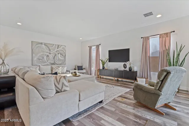 a living room with furniture white walls and a large window