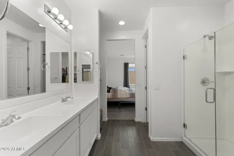 a spacious bathroom with a double vanity sink a mirror and shower