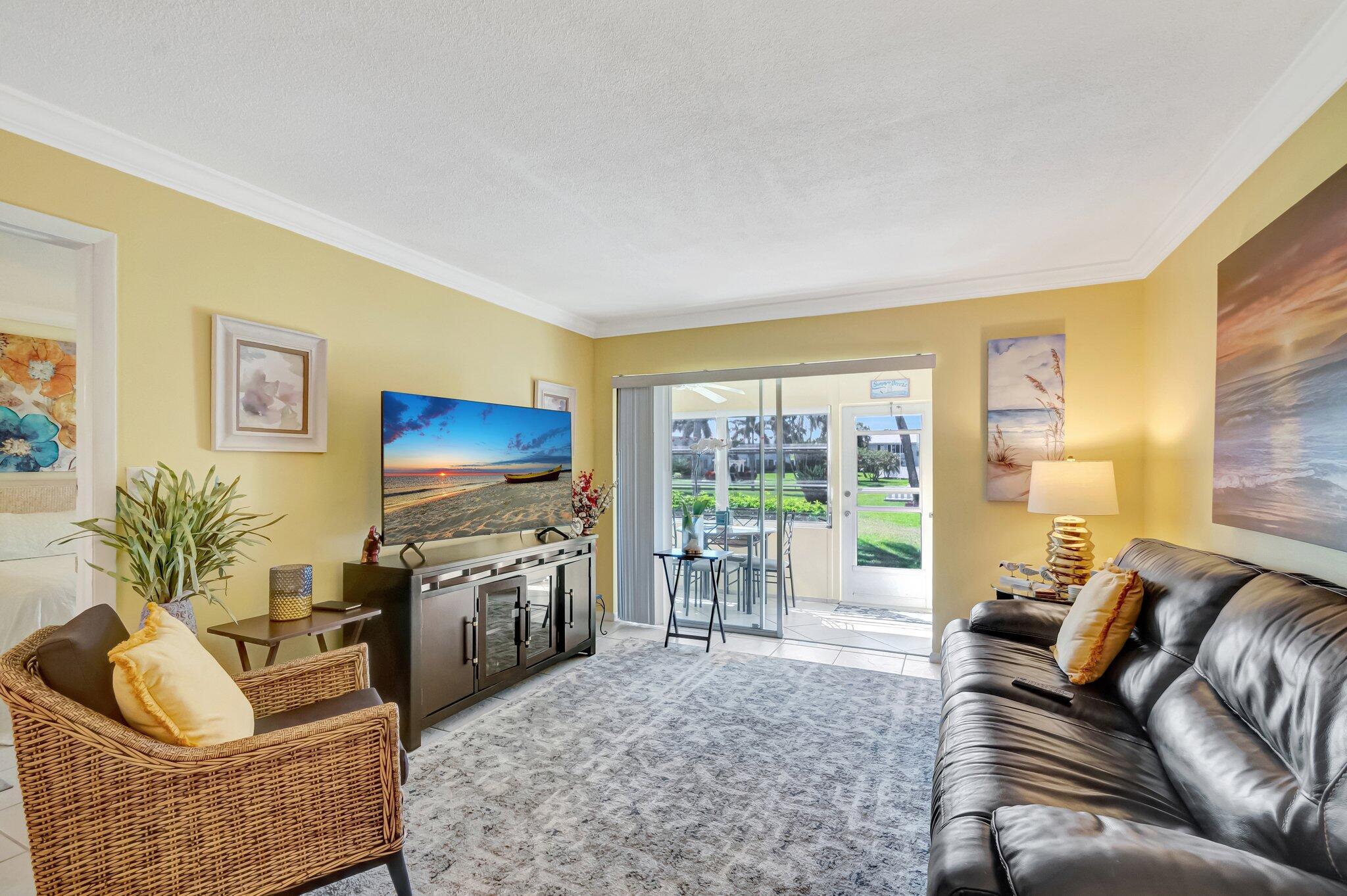 5550 North Ocean Boulevard, Unit 114 Ocean Ridge, FL 33435 - Photo 11 of 54 a living room with furniture couches and a flat screen tv
