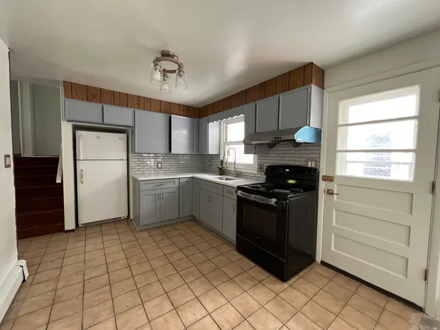 a kitchen with a refrigerator a sink and a stove top oven