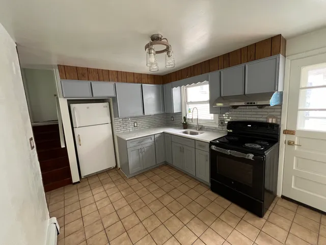 a kitchen with a sink a stove a refrigerator and cabinets